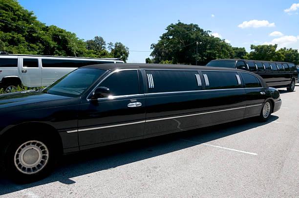 A black limousine parked in a parking lot, showcasing luxury and elegance for special occasions or events.